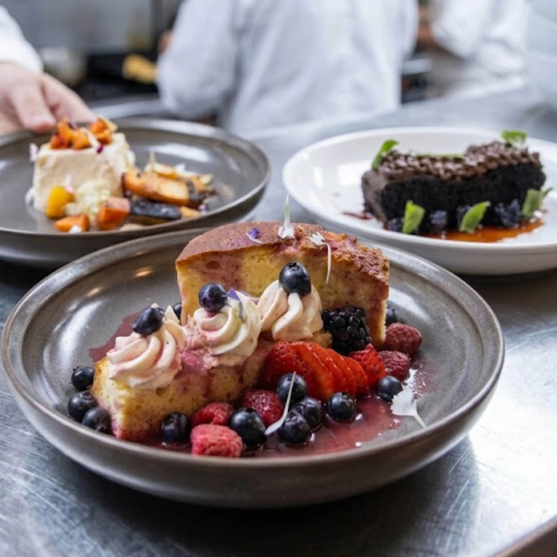 Seasonal dessert plates with berry olive oil cake, chocolate torte and whipped cream