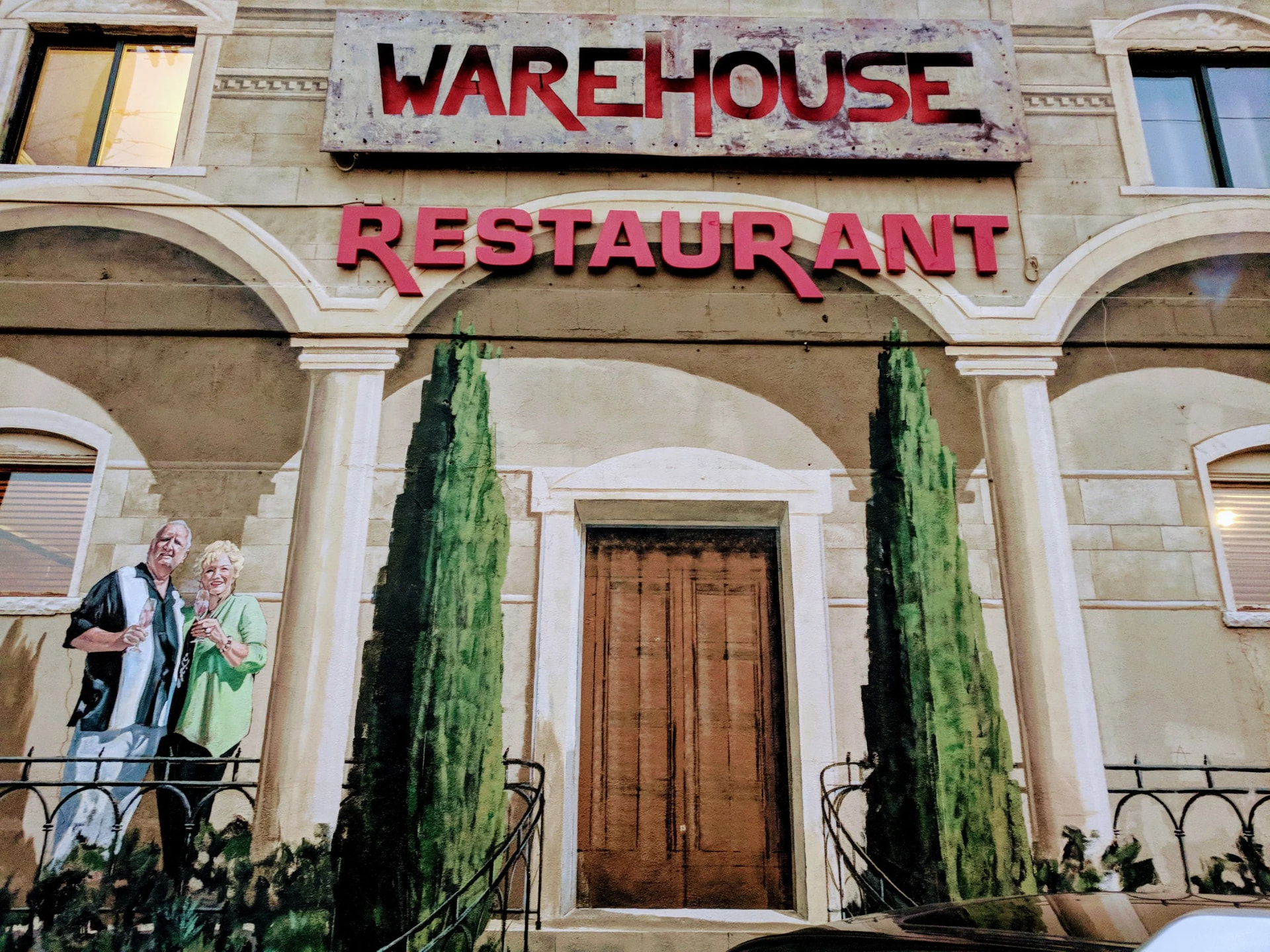 Close view of the Warehouse Restaurant mural and painted balcony beneath the red signage