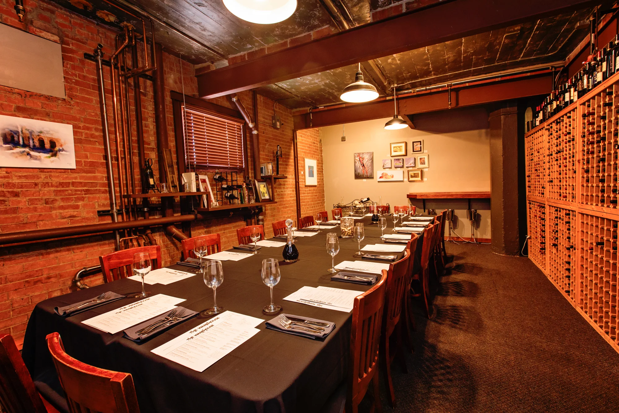 Private wine cellar dining room with long table and floor-to-ceiling wine racks