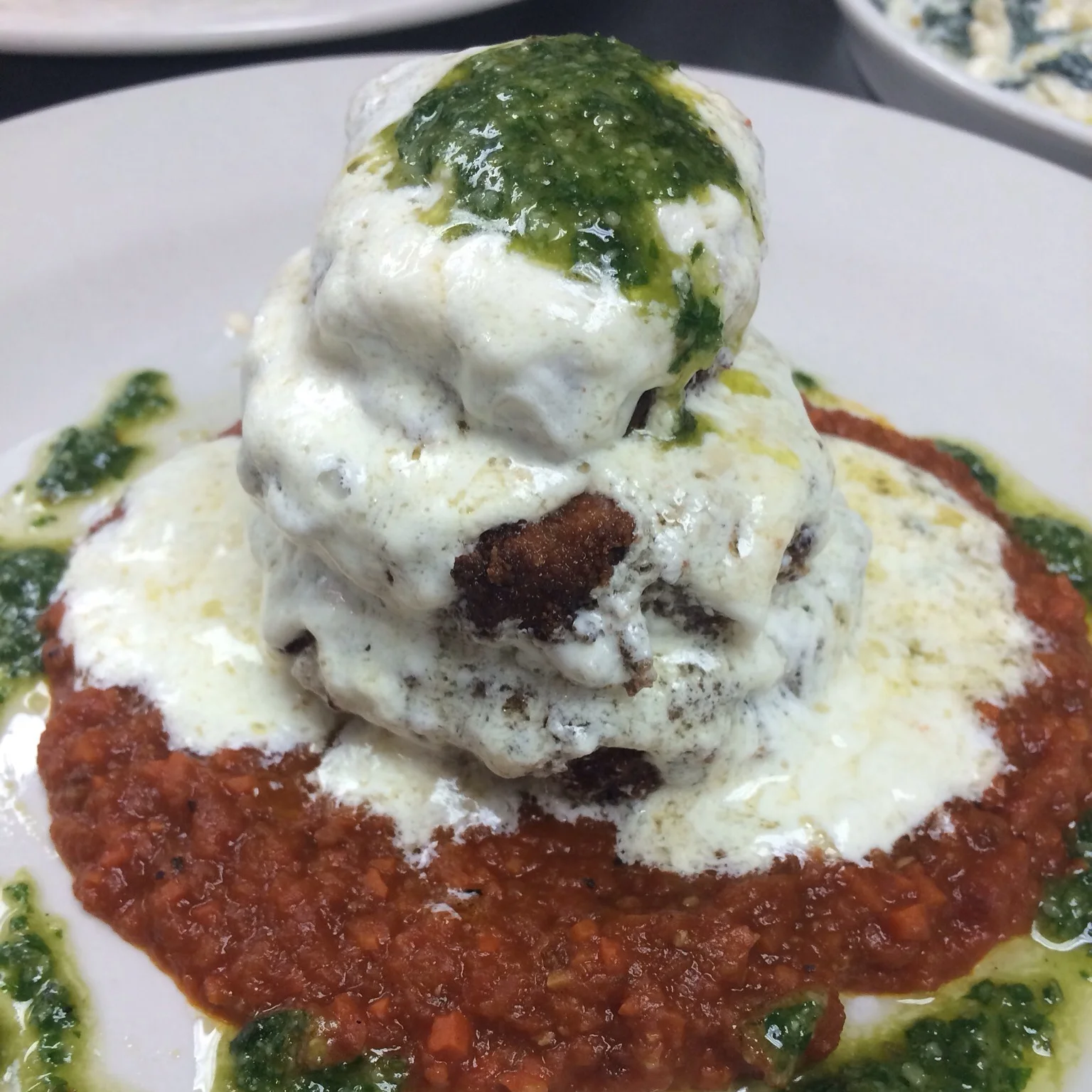 House meatballs with mozzarella, pesto and roasted tomato sauce
